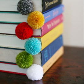 photo of pom pom bookmarks in a stack of books
