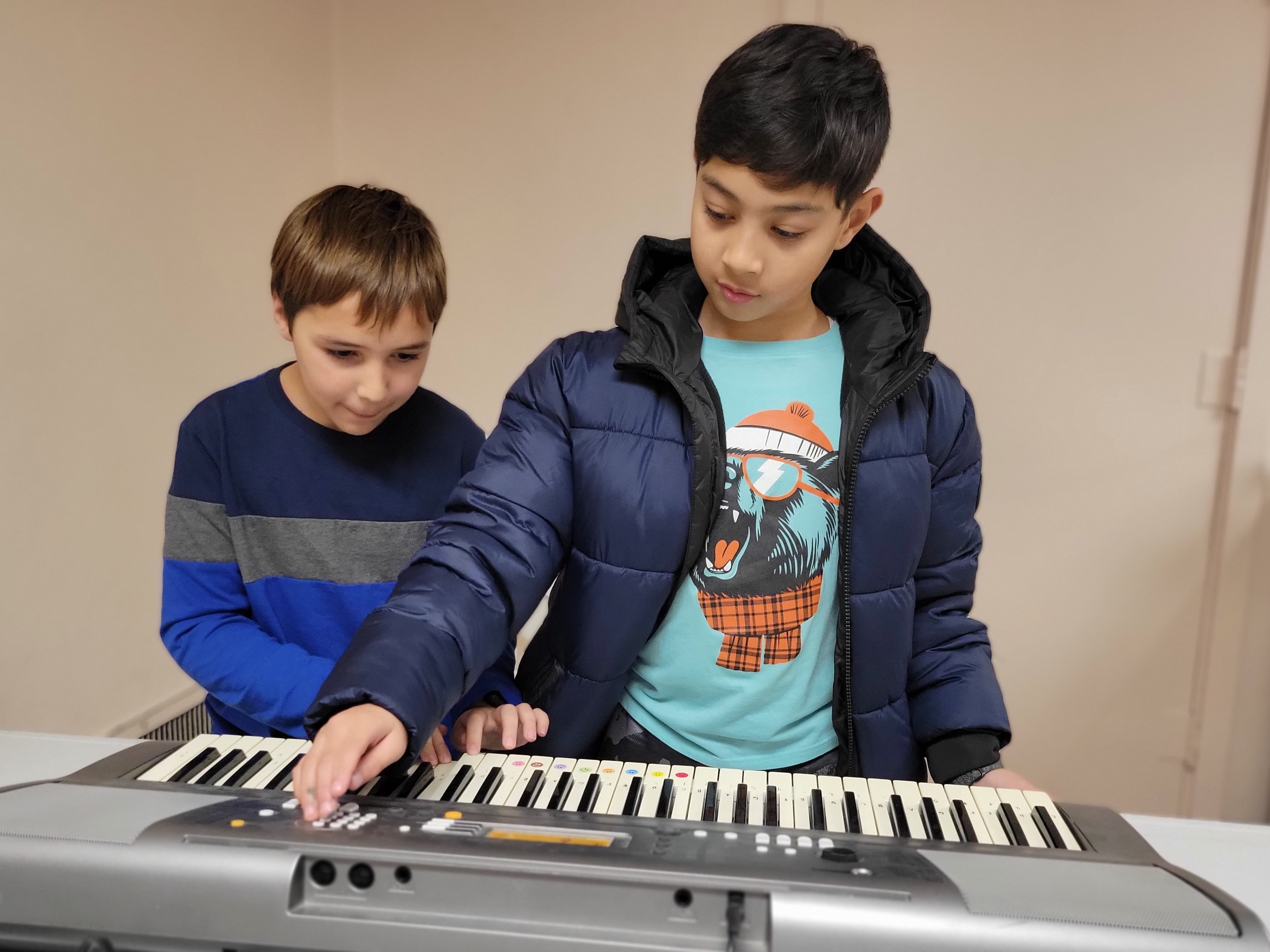 Boys enjoying playing keyboard at Faxon Tween Den