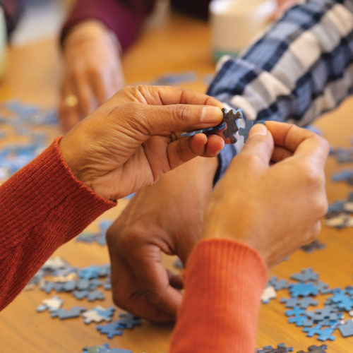 Close-up photo of hands holding puzzle pieces