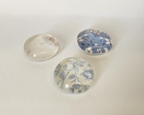 three glass magnets decorated with floral patterns