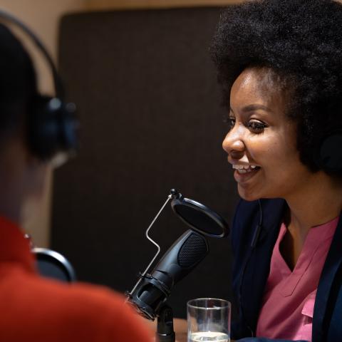 two people talking with microphones and headphones