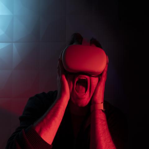 Man wearing VR headset frightened