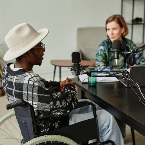 two people sitting and talking in front of microphones
