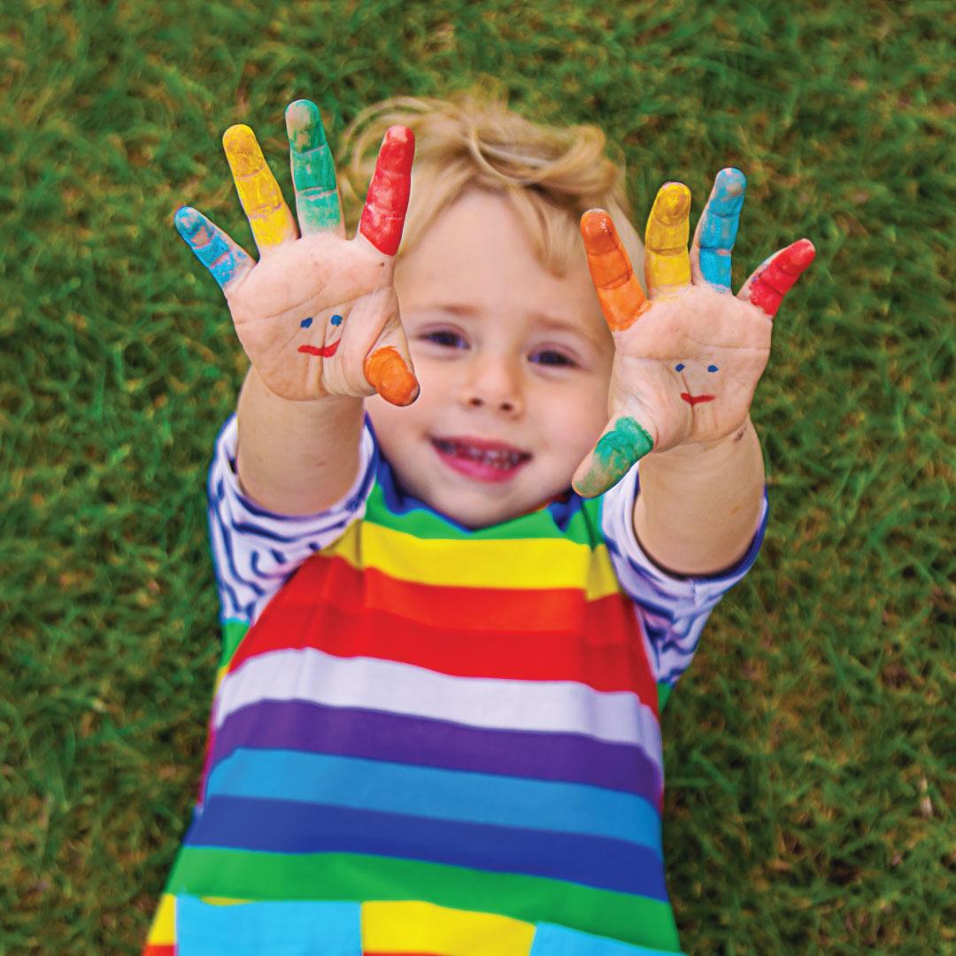Child with colorfully painted hands - photo