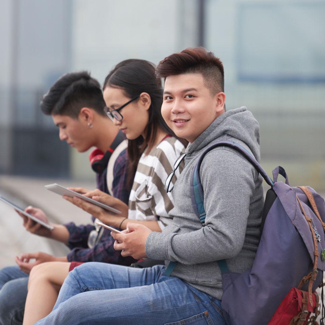 photo - college students sitting outside with tablets